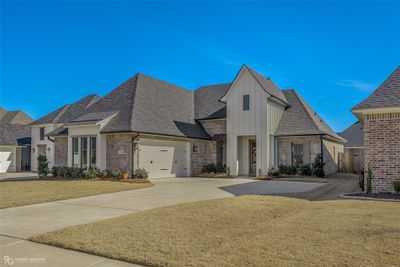 French country style house with a front lawn and a garage | Image 1