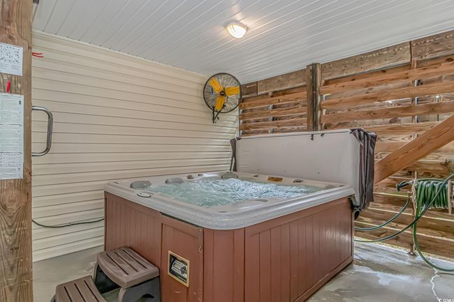 Miscellaneous room featuring a jacuzzi, wooden walls, and concrete flooring | Image 25