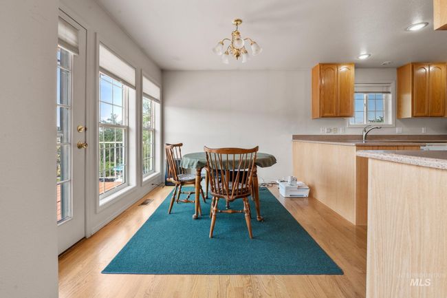 Dining room with healthy amount of natural light, light wood finished floors, a chandelier, and recessed lighting | Image 7