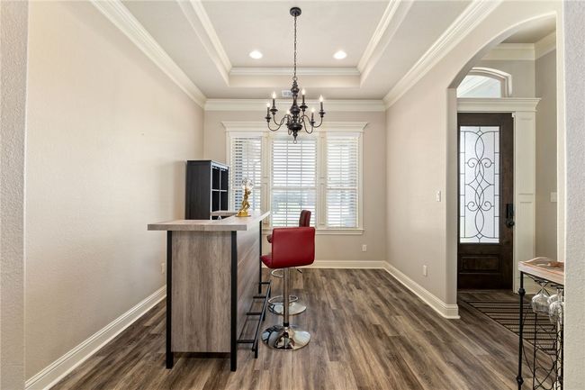 Ample space awaits for a large dining table and chairs—perfect for hosting dinner guests. The eye-catching tray ceiling with recessed lighting adds a stylish architectural touch. | Image 5