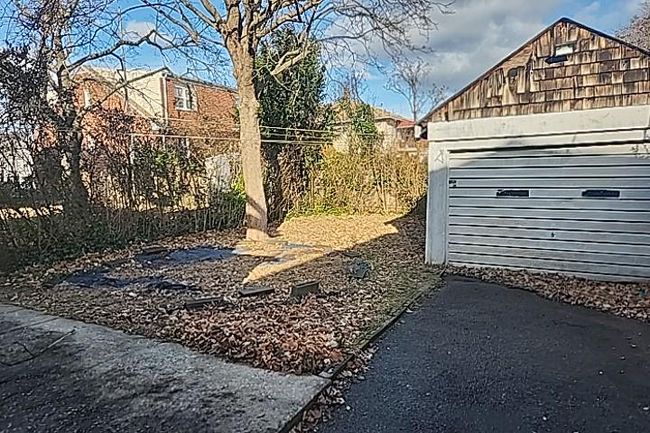 View of yard featuring a garage and an outdoor structure | Image 13
