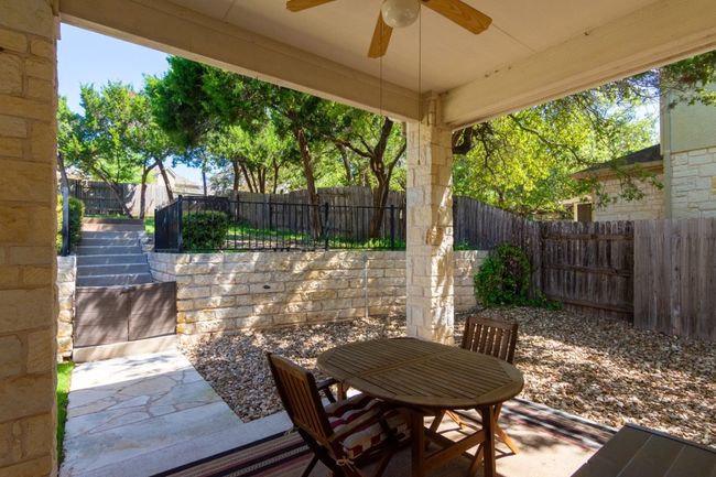 View of patio with a fenced backyard, ceiling fan, outdoor dining space, and stairs | Image 20