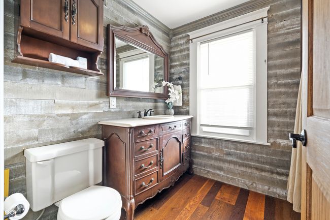 bathroom featuring vanity, dark wood finished floors, and crown molding | Image 38