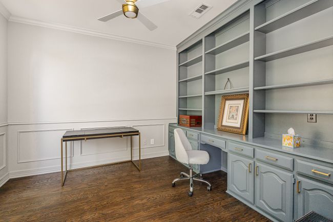 Office with ornamental molding, ceiling fan, hardwood flooring, built in desk and shelves | Image 14