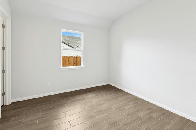 Empty room with wood finished floors, lofted ceiling, and baseboards | Image 16