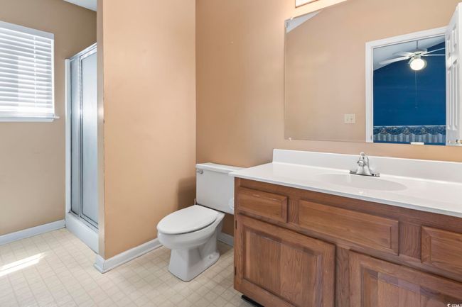 Full bathroom featuring vanity, toilet, a shower stall, and a ceiling fan | Image 20