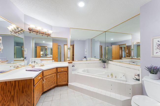 The attached master bathroom is spacious with a jetted tub and large vanity. | Image 17