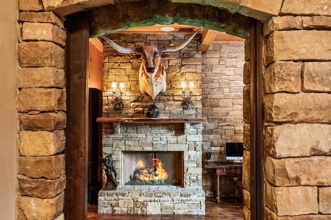 Detailed view of wood finished floors and a stone fireplace | Image 16