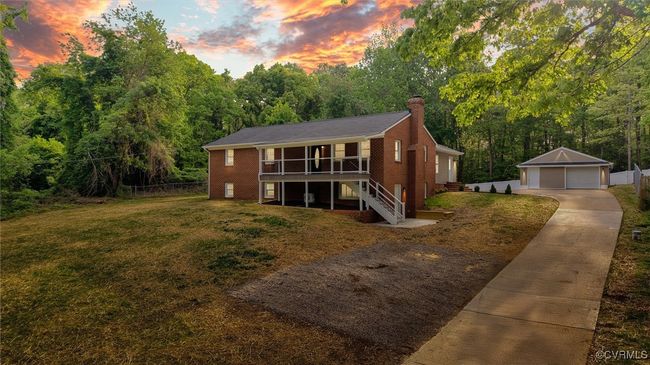 View of front of house featuring a chimney, fence, an outbuilding, a detached garage, and stairs | Image 47
