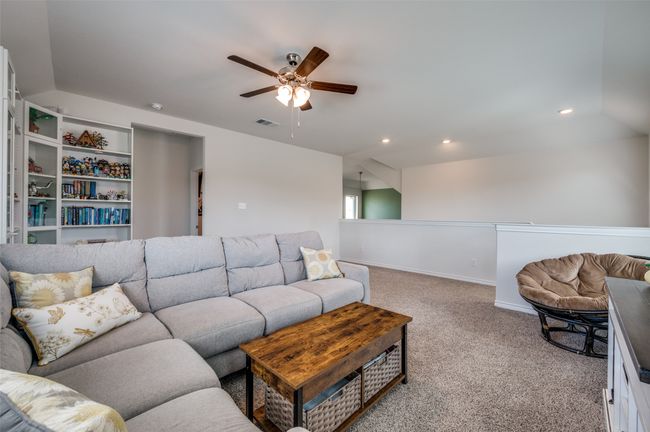 Carpeted living area featuring visible vents, baseboards, ceiling fan, recessed lighting, and vaulted ceiling | Image 16