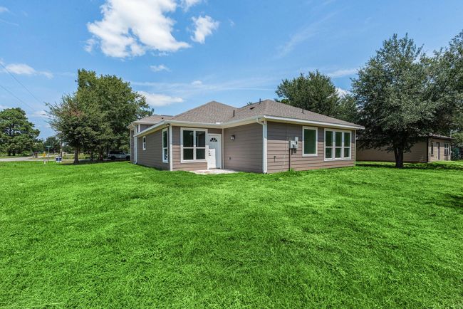 Charming one-story home with a modern exterior, large windows, and a spacious, lush green yard. Ideal for families seeking a blend of comfort and outdoor space. | Image 4