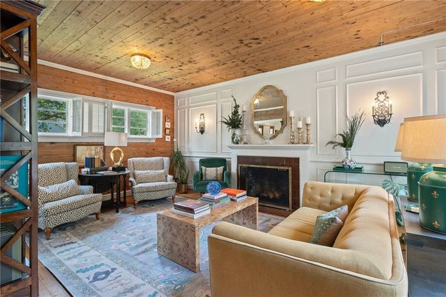 Living area with wood ceiling, a tile fireplace, and wood finished floors | Image 4