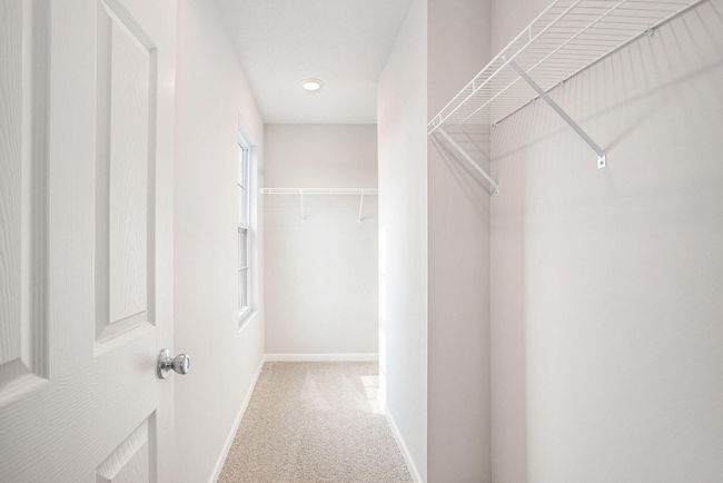 The primary suite includes a private bath and an oversized walk-in closet with a front facing exterior window to optimize natural lighting. | Image 12