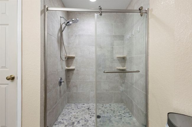 Bathroom featuring a textured wall and a stall shower | Image 28