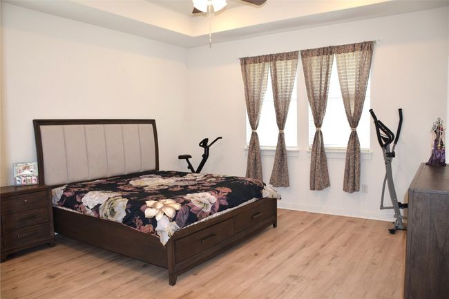 Bedroom with light wood finished floors, baseboards, and a ceiling fan | Image 10