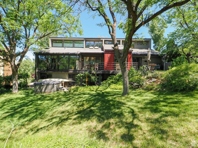 Rear view of property featuring a hot tub, a lawn, and a wooden deck | Image 61