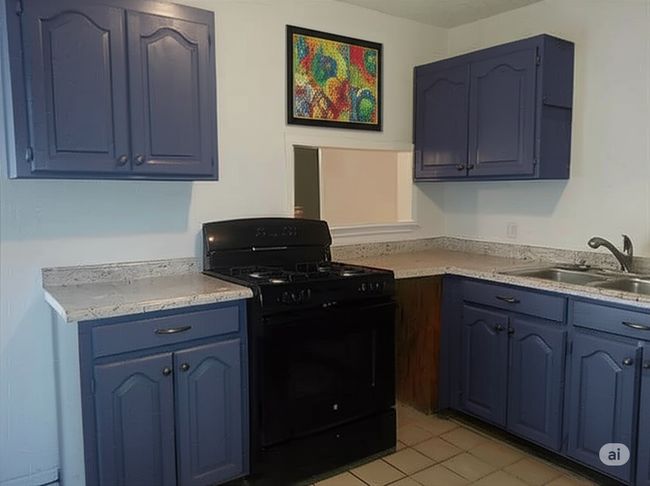 Kitchen with black range with gas cooktop, blue cabinets, light countertops, and light tile patterned floors | Image 10