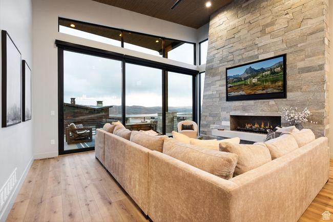 Living room with light wood-style flooring, visible vents, baseboards, recessed lighting, and a stone fireplace | Image 19