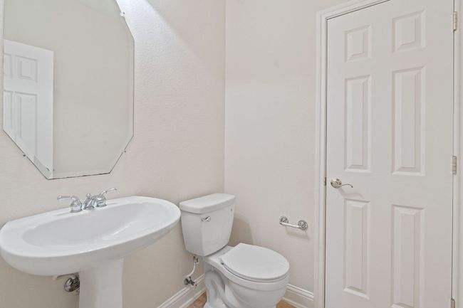 Half bathroom featuring baseboards, toilet, and a sink | Image 32