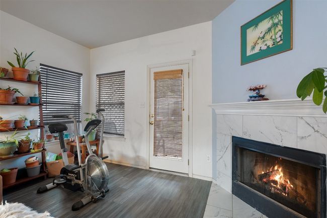 A large archway from the kitchen overlooks the dining and living with a corner fireplace with tile surround. | Image 17