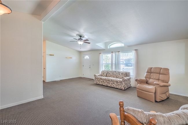 Carpeted living area with ceiling fan and baseboards | Image 10