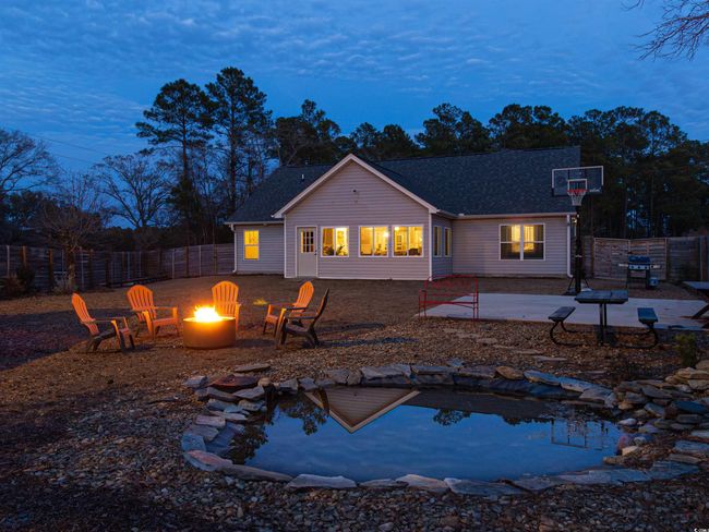 Back house at dusk featuring an outdoor fire pit and a patio area | Image 37