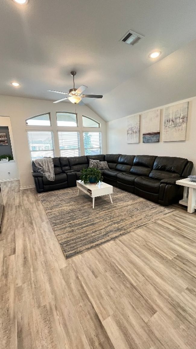 Living room with wood finished floors, vaulted ceiling, a ceiling fan, recessed lighting, and baseboards | Image 15