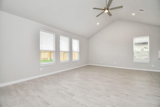 Welcome family and guests to your charming living room! With its high ceilings, recessed lighting, ceiling fan, custom paint, beautiful flooring, and large windows that let in abundant natural light, this room is perfect for gatherings. | Image 18