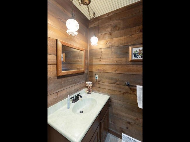 Convenient 3/4 bath featuring stylish barn wood walls for a rustic touch. | Image 33