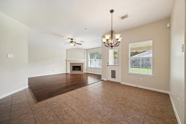 Adjacent to the kitchen, the dining area provides a comfortable space for family meals and gatherings, enhanced by elegant lighting fixtures. For your furry pets, you can see a new pet door to allow them easy access in and out! How wonderful is that! | Image 10