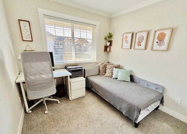 Bedroom featuring ornamental molding, light colored carpet, and an office area | Image 21