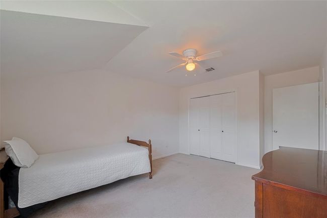 Spacious third bedroom featuring ample natural light, a cozy ceiling fan, and generous closet space—perfect for relaxation or a guest retreat. | Image 25