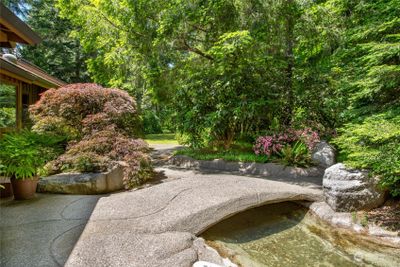 Bridge over the water feature invites you in. | Image 3