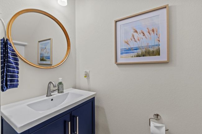 A chic half bath with designer fixtures and bold navy vanity offers a stylish, sophisticated touch for your guests. | Image 16