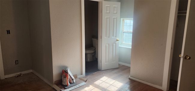 Hall with wood finished floors and a textured wall | Image 15