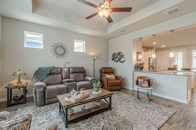 Living room featuring a raised ceiling, wood tiled floors, and ceiling fan | Image 8