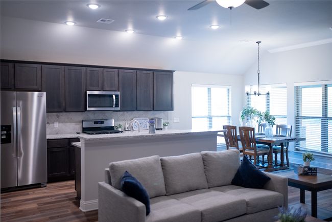 Living room with dark wood-style floors, visible vents, lofted ceiling, and plenty of natural light | Image 8