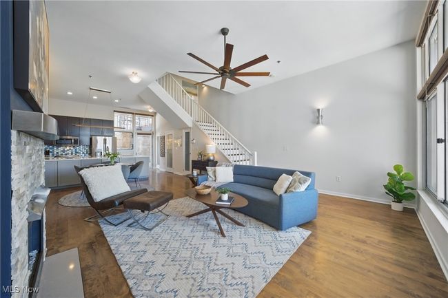 Living room with stairway, a ceiling fan, baseboards, and wood finished floors | Image 8