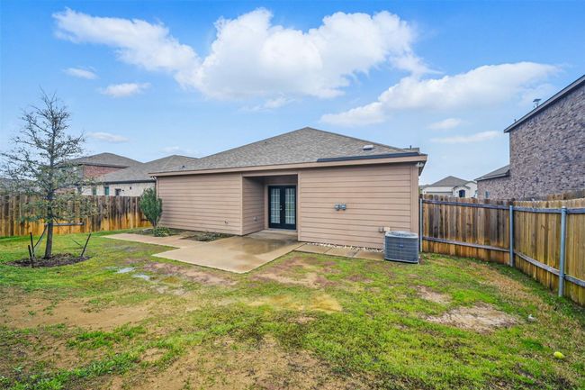 Back of house with central air condition unit, a yard, a fenced backyard, a patio, and french doors | Image 19
