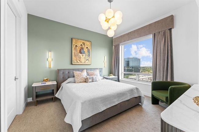 This bedroom features a stylish design with a soft green accent wall, modern lighting, and a large window. | Image 12