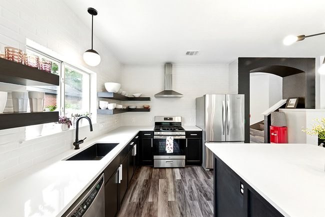 Kitchen featuring open shelves, a sink, light countertops, stainless steel appliances, and wall chimney exhaust hood | Image 7