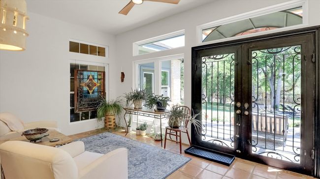 One of two iron double door exits to the back patio . Ceiling Fan with wood blades is matching to the ceiling fan at the second iron French door exit. | Image 8