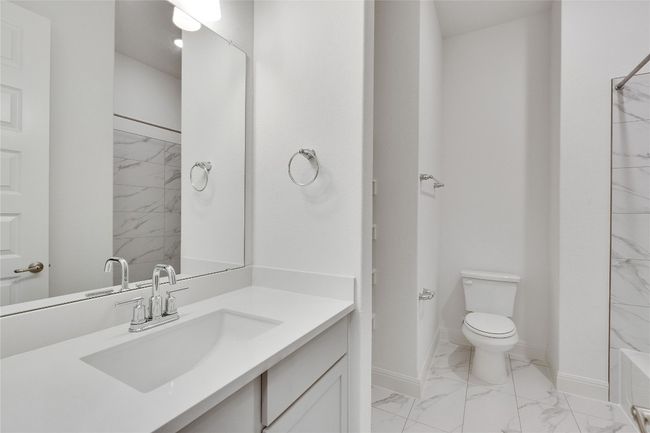 Full bathroom with marble finish floors, vanity, and shower combination | Image 12