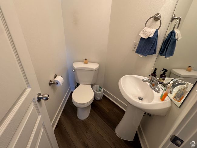 Bathroom with toilet, baseboards, a sink, and wood finished floors | Image 7