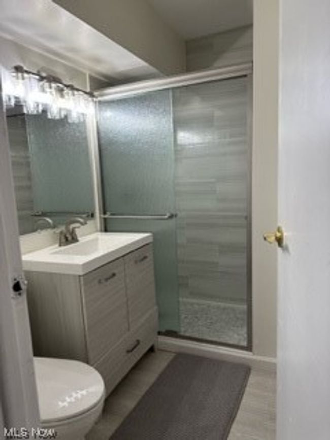 Master Bathroom featuring large vanity, a shower with shower door, and toilet | Image 13