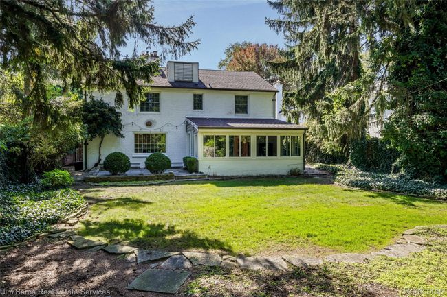 Rear view of property with a sunroom, a yard, and brick siding | Image 32