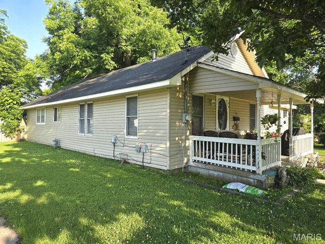 View of side of property featuring covered porch and a lawn | Image 21