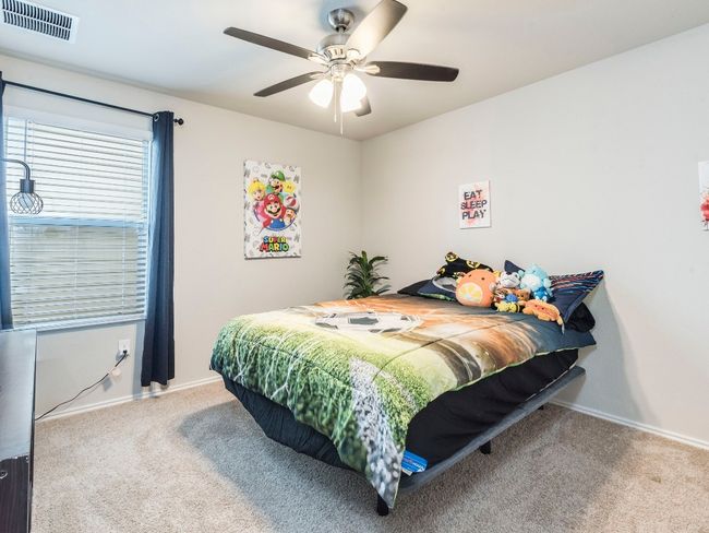 Carpeted bedroom featuring a ceiling fan, baseboards, and visible vents | Image 23