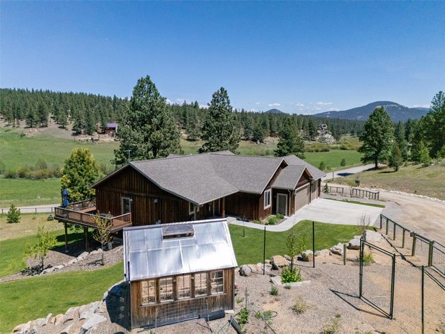 View of front of home featuring concrete driveway, a mountain view, and board and batten siding | Image 59
