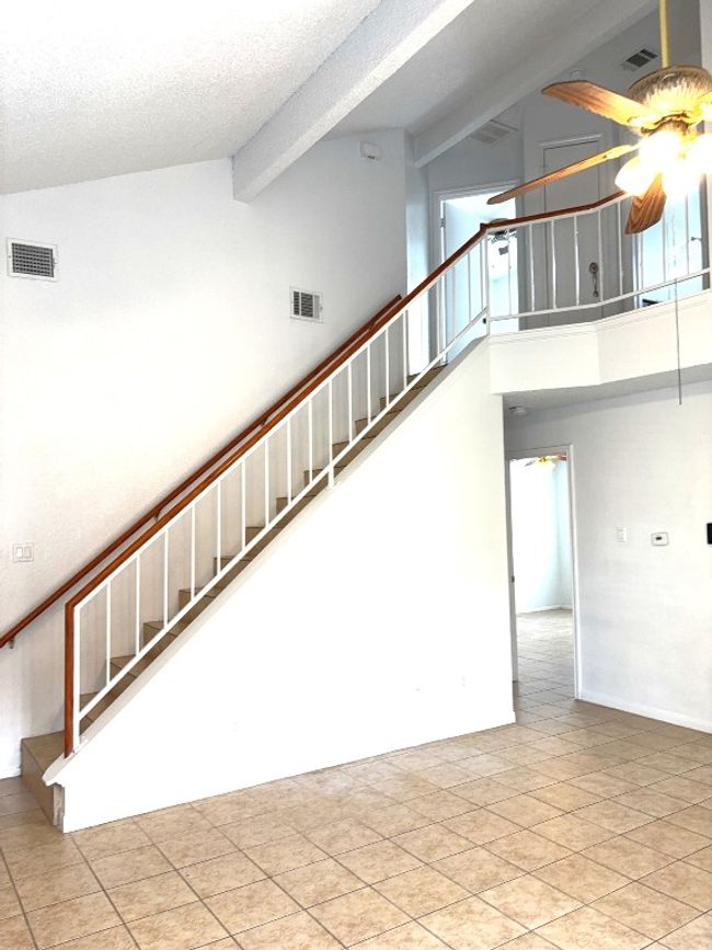 Stairs featuring a ceiling fan, high vaulted ceiling, beamed ceiling, and a textured ceiling | Image 4